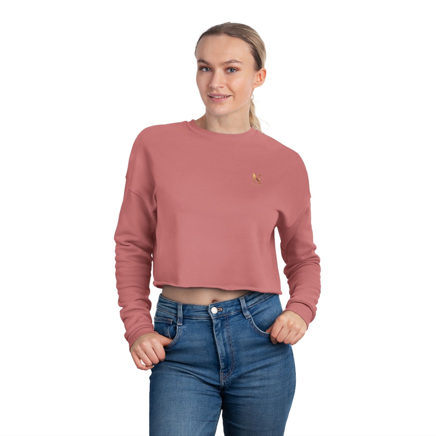 Woman wearing a pink cropped sweatshirt and blue jeans on a white background